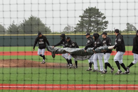 The Skyline Trojans brings in a tarp to cover the pitcher’s mound during the game at Skyline College on March 12, 2016.