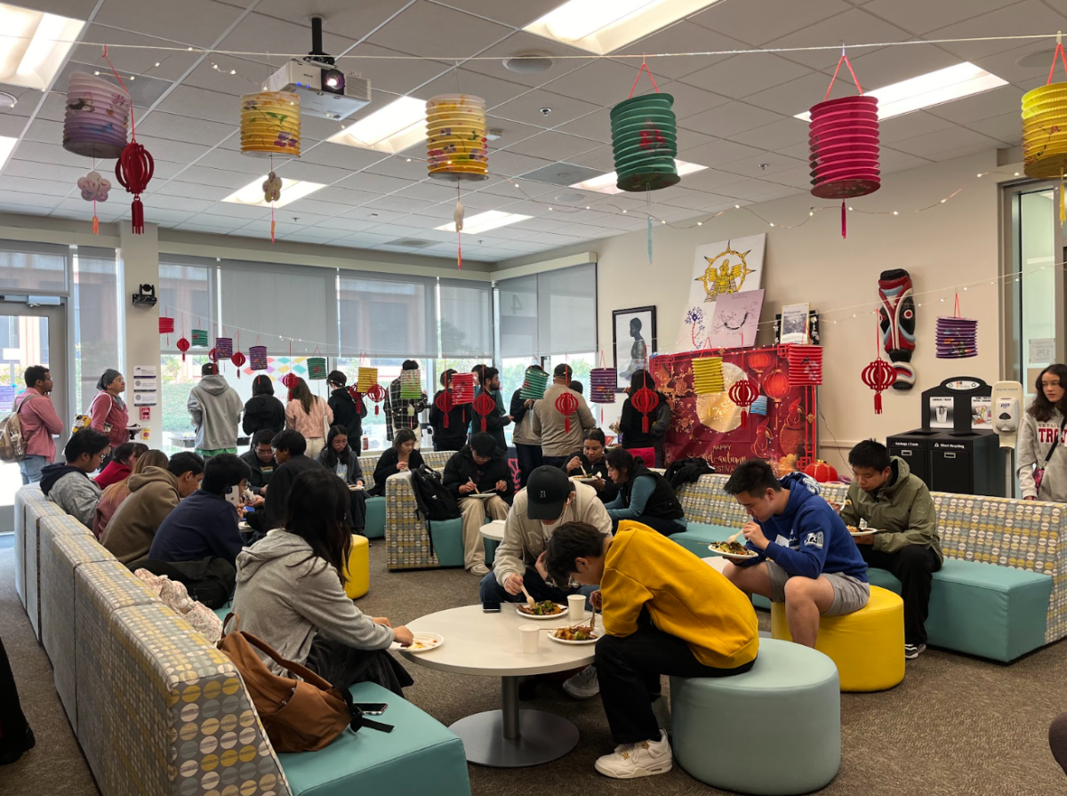 Students converse and eat together as they attend the Mid-Autumn Festival. 