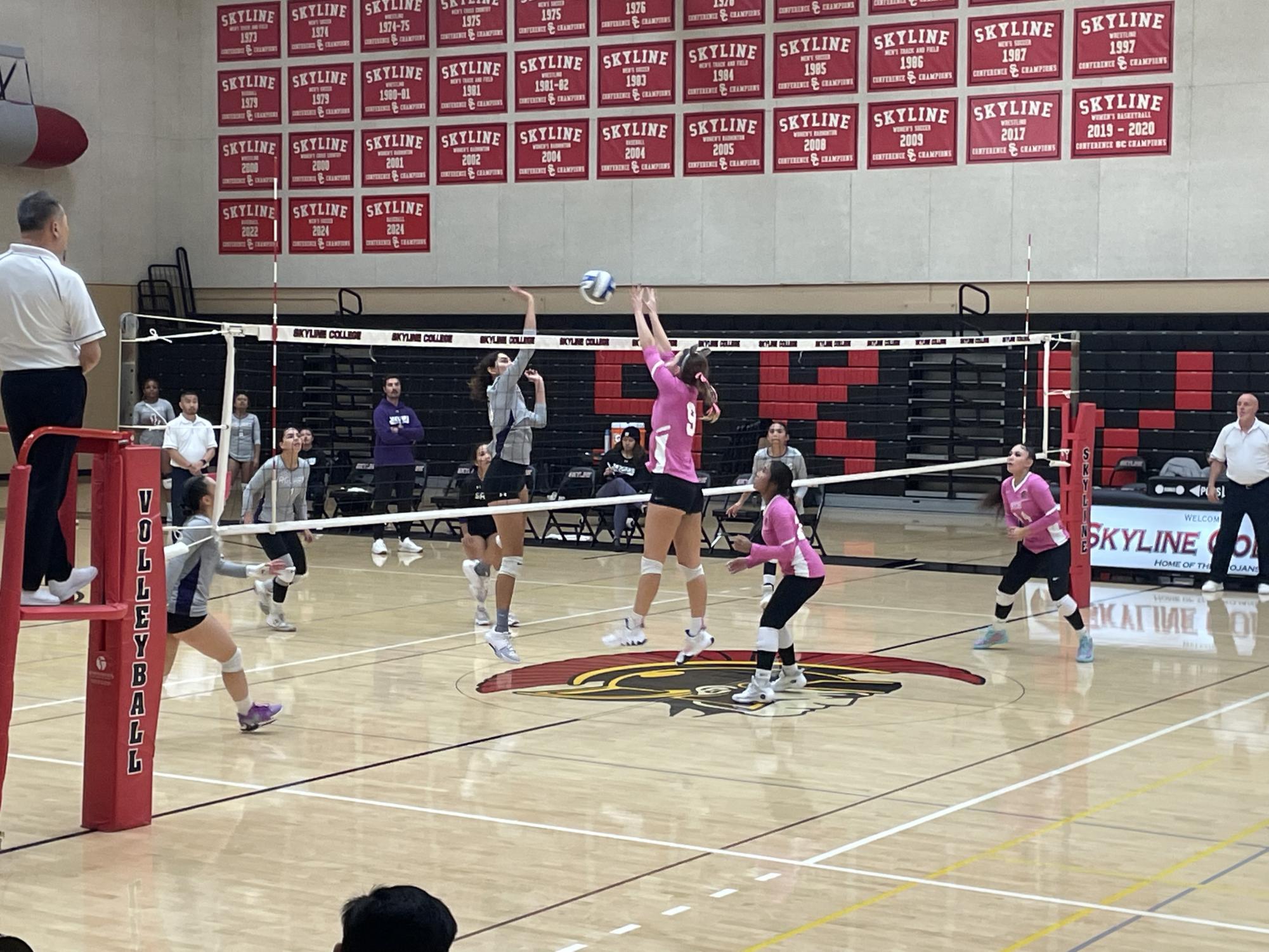 Outside Hitter, #9, Sasha Grett jumps to block the spike from SJCC.