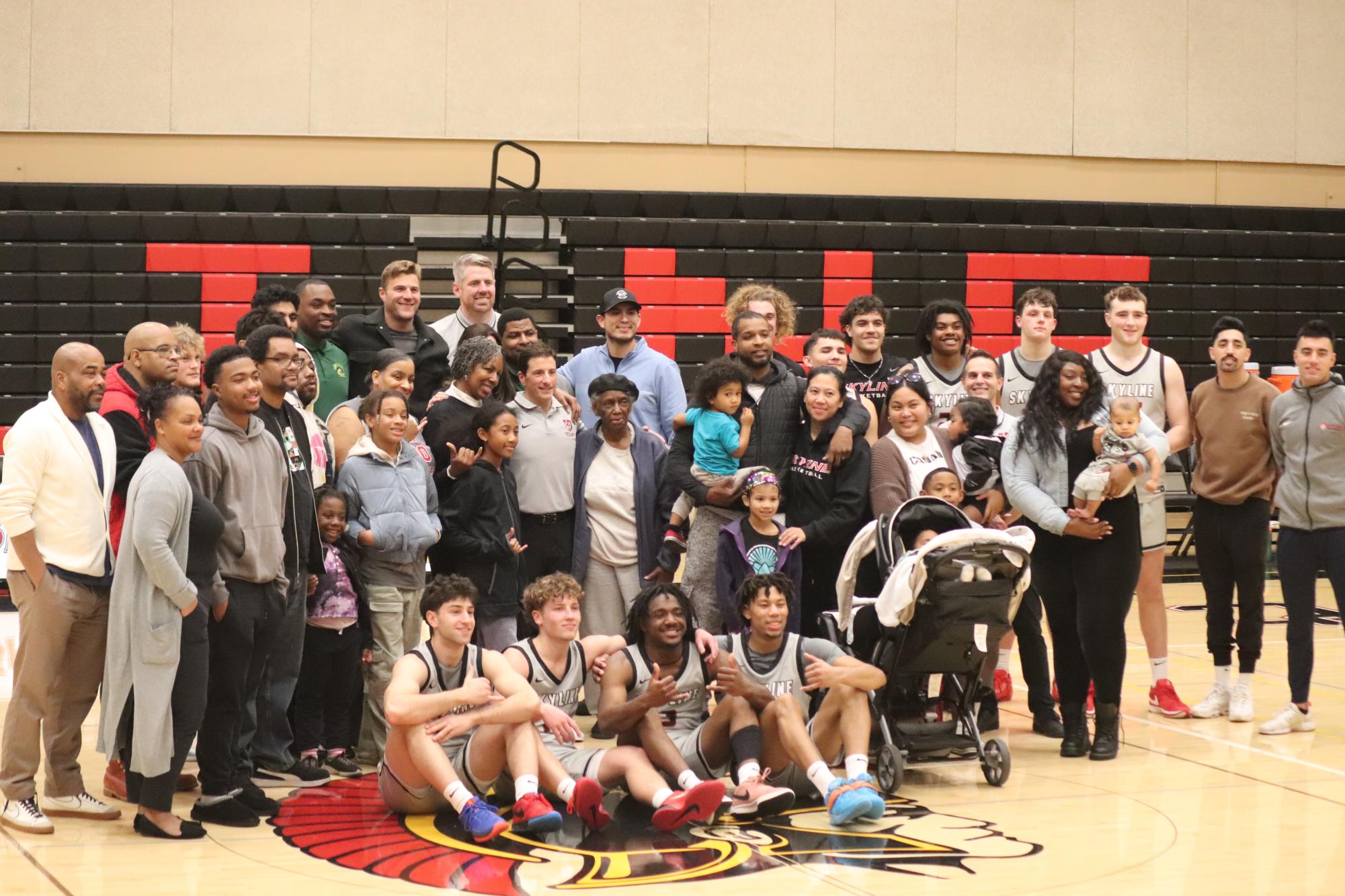 KeDraun Buckner's family, former teammates, and Skyline Basketball team pose for a photo after securing victory.