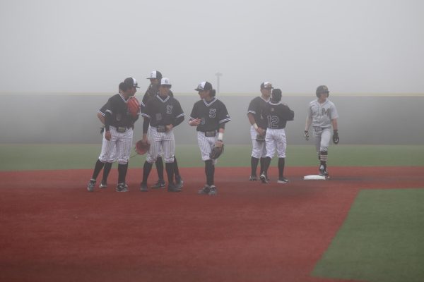 Skyline baseball waits to hear whether the game will continue due to the sudden heavy fog.