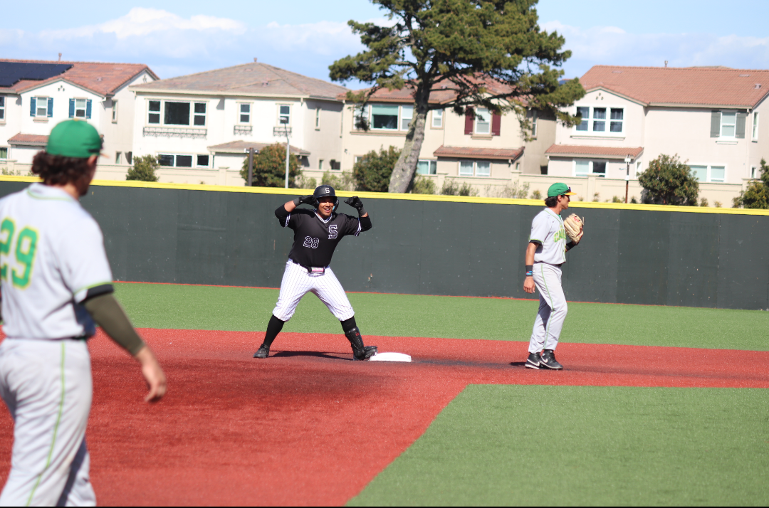 Freshman first baseman Nick Tobin (center) celebrates at second base after hitting a double.